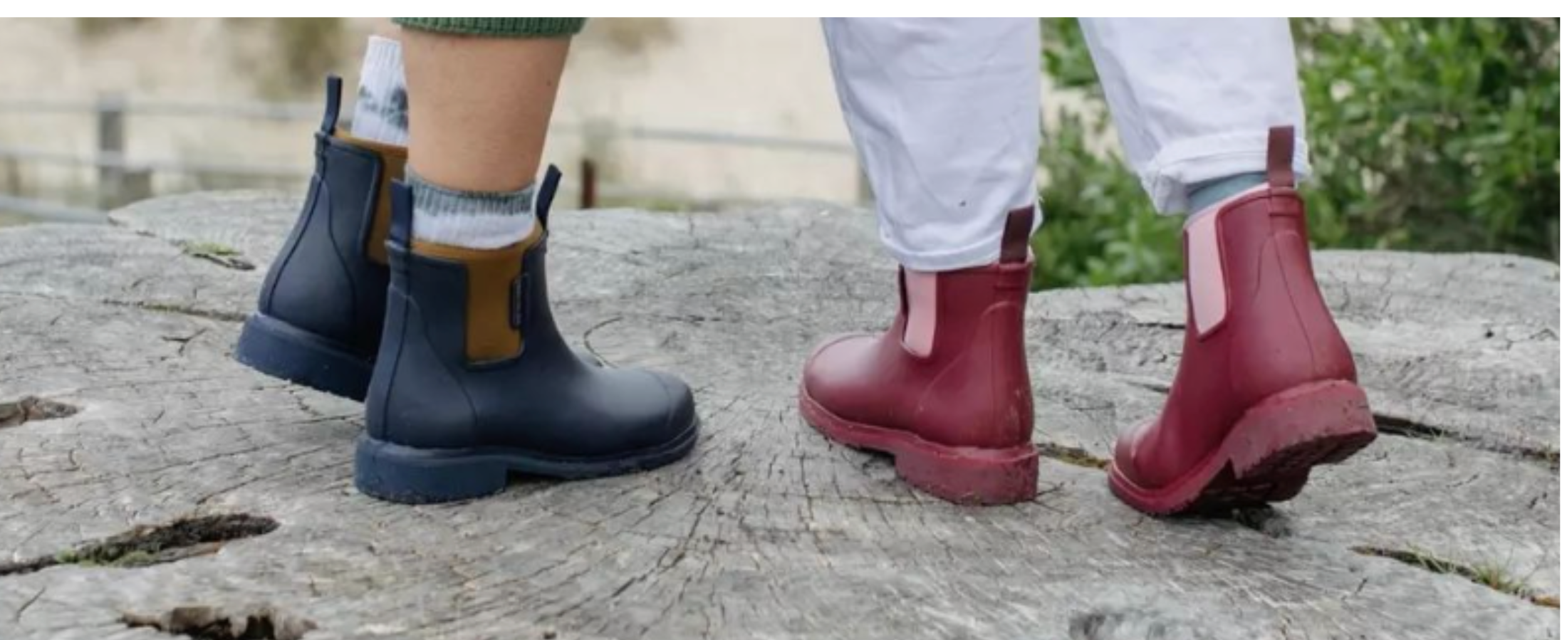 Two people standing on a tree stump wearing Bobbi gumboots